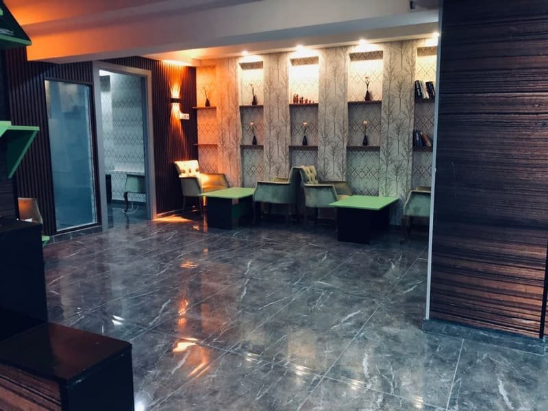 Aydınlatmalı duvar rafları ve masalı oturma bölümünün diğer açıdan görünümü