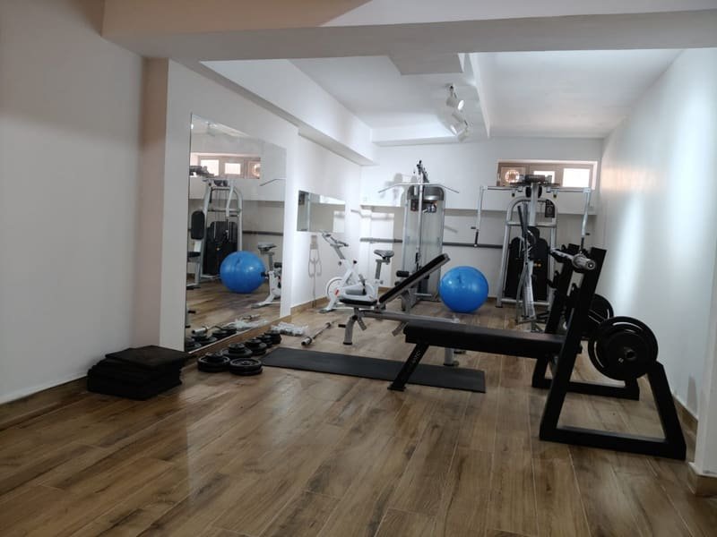 Ağırlık istasyonları, bench ve pilates toplarının bulunduğu spor ekipmanı alanı